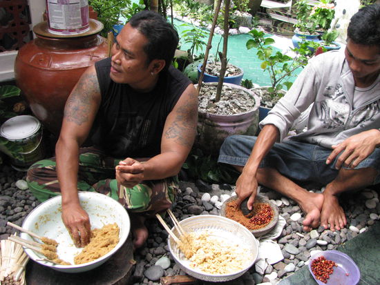 Poulet-Satay und Erdnuessli werden verstampft fuer die Sauce.