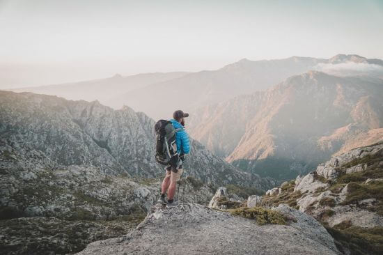 Bild eines Bergsteigers mit Blick über's Tal.