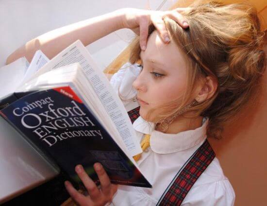 Ein Mädchen liest im Oxford English Dictionary.