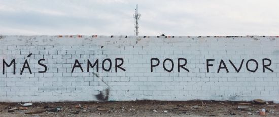 Grafitti auf einer Mauer: Mas amor por favor.