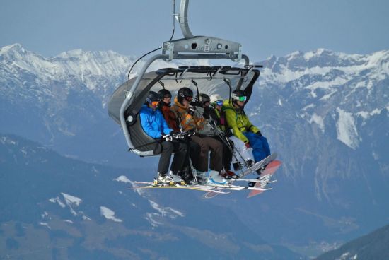 Bild eines voll besetzten 6er Skilifts.