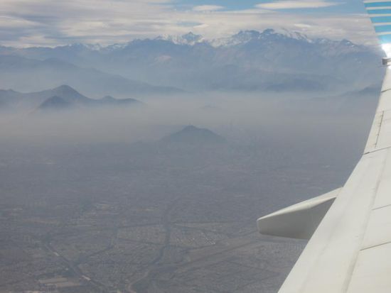 11 Stunden später (bzw. laut Uhrzeit 7h früher) kommen die Anden in Sicht - und die Hauptstadt Chiles, die unter der Smogglocke liegt.