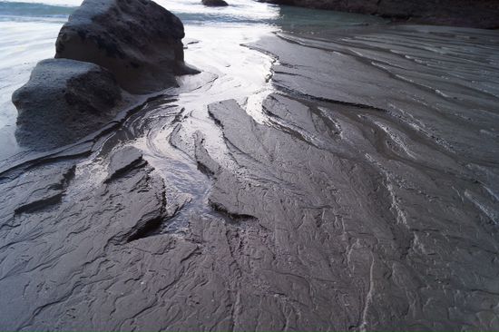 Wasser das nach der Flut wieder zurück in Meer läuft hinterlässt wahre Kunstwerke im Sand.