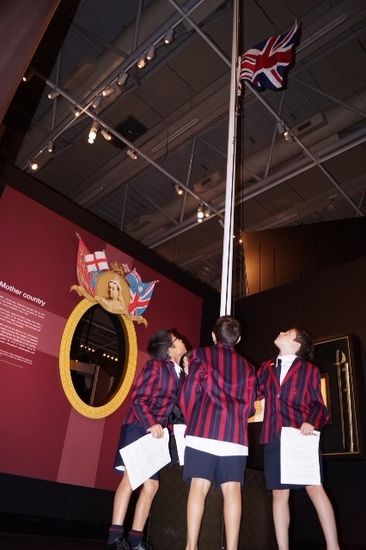 Schülerklasse im Museum beim Hissen der englandflagge.