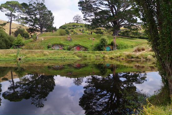 Hobbiton spiegelt sich im See.