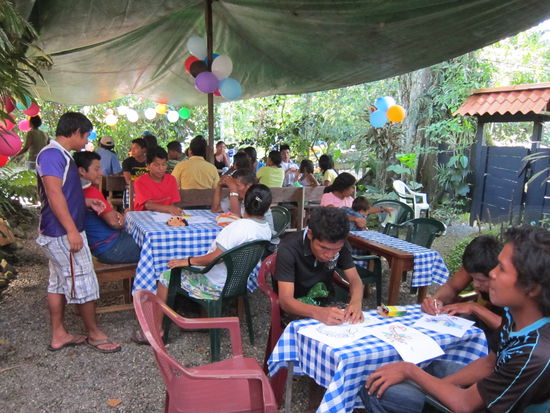 Ungefähr 100 Leute wurden im Garten bedient. 
Ungewöhnlich: Im Vordergrund sieht man 2 Erwachsene Männer Bilder ausmalen. Viele Eingeborene kennen solche Sachen nicht von ihrer Kindheit und freuen sich über die Bilder