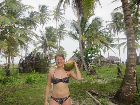 ...und Kokosnüsse, Handarbeiten oder Fische vom einheimischen Volk kaufen. Im Hintergrund sieht man die spärlichen Hütten der sogenannten Kuna.