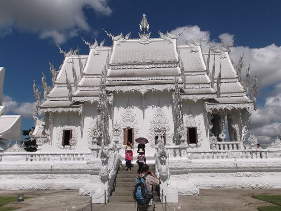 Kurz vor Chiang Rai habe ich einen wunderschönen weissen Tempel gesehen. Den muss ich Morgen genauer unter die Lupe nehmen. Nach 3 Std. sind wir pünktlich in Chiang Rai angekommen. Ich hatte schon ziemlichen Kohldampf, weil ich am Abend nichts gegessen hatte, und das Frühstück mit dem luftigen Toastbrot nicht sehr lange hinhält. Im Reiseführer habe ich mir unterwegs einige Guesthäuser markiert, die ich ansteuern wollte. Beim Bus Terminal standen schon Tuktuk Fahrer und warteten auf Gäste. Ich nannte ihm mein ausgewähltes Haus und liess mich von ihm dorthin fahren. Aber nicht, ohne dass ich seinen Preis noch etwas drückte. Wie sich im Nach hinein herausstellte, hat der Tuk-Tuk-Fahrer einen ziemlichen Umweg gefahren, dass es die 80 Bath wert schienen. Meine Unterkunft war nämlich nur ca. 400m vom Bus Terminal entfernt.