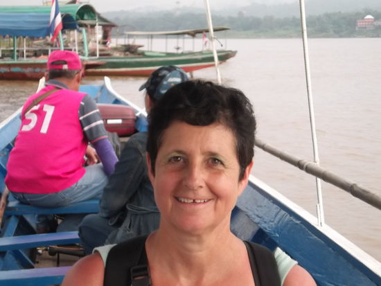 Für die Fähre bezahlte ich Fr. 1.20 und eine Viertelstunde später war ich bereits in Laos. Dort ging ich schon routiniert zum Einreiseschalter, wo mir der Beamte zuerst ein Formular vor die Nase hielt, das ich zuerst noch ausfüllen sollte. Befohlen, getan und wieder zum Schalter. Dort hatte es der Beamte aber gar nicht eilig und ich wartete geduldig, bis er sich bemühte, mich zu bedienen. Ich schnappte meinen schweren Koffer und zog ihn keuchend die steile Strasse hoch. Und dann wartete ich und wartete und wartete, bis es mir zu bunt wurde. Ich nahm mein Handy zur Hand und rief meinen Reise-Anbieter an, um zu erfahren, wo der Reiseleiter denn sei. Leider funktionierte meine Handyverbindung nicht, und so fragte ich in einem Travel-Agent-Büro, ob sie mir helfen könnten das Reisebüro in Vientiane anzurufen. Die Frau war so freundlich, stellte die Nummer ein und kam sogar durch. Meiner Sachbearbeiterin erkärte ich, wer und wo ich war. Sie versprach mir, alles abzuklären und mich zurück zu rufen. Ich wartete wieder eine viertel Stunde, und als nichts geschah, rief ich nochmals an. Dann bestätigte mir die Sachbearbeiterin, dass der Reiseleiter am Hafen auf die Gäste warte. Ich fragte im Reisebüro, ob ich den Koffer dort lassen dürfe und spiedete also wieder zum Hafen hinunter. Dort sah ich bereits eine Gruppe Leute um einen jungen Mann mit einem pinkigen T-Shirt stehen. Dieser hielt eine Liste in der Hand, wo auch mein Name darauf stand. Als ich mit einem der ersten Boote in Houei Xei eintraf, war aber noch kein Reiseleiter zu sehen, darum machte ich mich selbständig auf den weg und wartete wie vorher erwähnt an der Strasse. Nun aber war meine Schiffsreise gerettet. Mit der Gruppe ging ich gemeinsam  zur Hauptstrasse hoch. Das ganze Gepäck wurde von den Trägern auf das Dach des Taxis gehoben. und wir durften hinten auf dem Pick-up Platz nehmen. Ich habe mich auf der Fahrt bei den anderen Mitreisenden vorgestellt und dabei hat sich Uta als Deutsche geautet. War ich froh, dass noch jemand dabei war, der deutsch sprach. Nach einer kurzen Fahrt sind wir an einem anderen Hafen angelangt, wo verschiedene Slowboote auf ihre Gäste warteten.