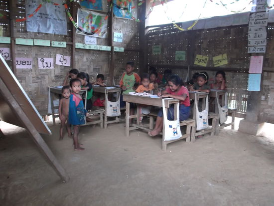 Zwei Schulzimmer sind in einer Hütte untergebracht. In einer Klasse sind ungefähr 30 Kinder, die jüngsten erst 5 Jahre alt. Die Schulbänke stehen auf dem Erdboden und die Kinder kommen barfuss zur Schule oder ziehen die Schuhe vor der Hütte aus, wie es auch in Thailand der Brauch ist. Der Lehrer kommt aus der Stadt und wird vom Staat bezahlt. Das Dorf bittet seine Besucher trotzdem um Schulmaterial oder Geld, um es zu kaufen.
Die Kinder werden während der ersten 6 Jahre in der Dorfschule unterrichtet und gehen dann auf der gegenüber liegenden Fluss-Seite in die Sekundarschule. Wenn sie weiter studieren wollen, müssen sie das Dorf verlassen und in die Stadt fahren.