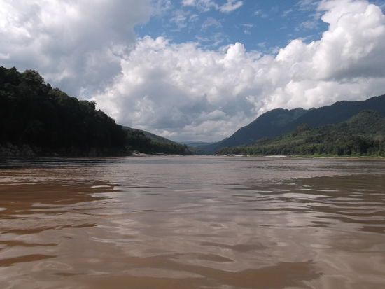 1 Stunde vor Luang Prabang, wo der Khong in den Mekong fliesst, legte unser Boot an, damit wir die Höhle mit den 1000 Buddhas besuchen konnten. Wir besichtigten zuerst die obere Höhle, wozu wir einige Treppen hinauf steigen mussten. Endlich mal wieder etwas Bewegung, dachte ich mir, und legte die Paar Stufen ohne Mühe zurück, die anderen keuchten gaaanz langsam die Stufen hoch. Oben angelangt hatte man eine wunderschöne Aussicht auf das Mekongbecken. Ich kann mir gut vorstellen, wie das bei Hochwasser aussehen würde. Das wäre wie ein grosser See. Um die Höhle besichtigen zu können bekamen wir Taschenlampen. Es war eine grosse Halle mit einigen Buddha Statuen drin, die vor dem Indochina-Krieg gerettet wurden. Die Höhle wurde aber berreits im 14. Jahrh. bewohnt, denn es waren auch spirituelle Figuren in Stein gehauen, zu sehen. Auf dem Weg in die untere Höhle sahen wir einige Kajaks mit Touristen, die von hier aus in Richtung Süden paddeln werden. Wir haben sie etwas weiter unten überholt, und es sah nicht sehr leicht aus, diese Kajaks vorwärts zu bewegen. Wahrscheinlich werden sie nur ein Teil der Strecke nach Luang Prabang paddeln, sonst kämen sie noch in die Nacht hinein.
Also in der unteren Höhle waren dann die 1000 Buddhas zu sehen. Es sei eine Tropfsteinhöhle. Wir haben aber von den Monolythen nicht viel gesehen.
