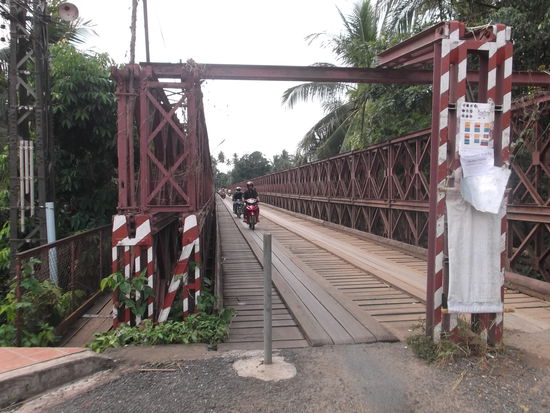 Also folgte ich der Strasse bis zum nächsten fahrbaren Übergang und schon war ich auf dern anderen Flussseite, wo Luang Prabang weiter hinaus gewachsen ist. Dort fuhr ich eine kleine Runde und kam über eine weitere Brücke wieder auf die linke Flussseite. Hier folgte ich einer Strasse immer dem Fluss entlang. Ich hatte eine grob skizzierte Karte von der Umgebung von Luang Prabang gekauft. Darauf war eine Strasse eingezeichnet, die um einen Hügel führte. Diesem Weg wollte ich folgen. Sehr schnell habe ich Luang Prabang hinter mir gelassen und es ging immer leicht Hügel hinauf und hinunter.