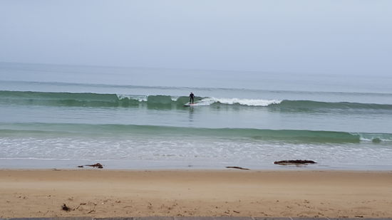 Eine Frau mit dem Stehpaddel am surfen