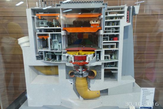 Oberhalb der Turbine steht ein kleiner Mensch.