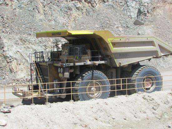Insgesamt 94 dieser großen Muldenkipper und 13 Löffelbaggern sind in der Kupfermine im Einsatz. 
Sie graben und transportieren täglich aus dem Tagebau rd. 600.000 to Erz. Um solche enormen Mengen bewältigen zu können,  muss ein Muldenkipper ca. 400 to bei jeder Fahrt, die knapp eine Stunde dauert, nach oben befördern. 
Da diese Maschinen enorm viel Geld kosten (Muldenkipper ca. 20 Mill. $) müssen diese rund um die Uhr laufen, und die Technik des Muldenkipper wird elektronisch überwacht. Die Daten werden an die Instandsetzungswerkstatt übertragen, sodass man jederzeit über den technsichen Zustand der Maschine informiert ist. Aufgrund dieser Daten werden die Muldenkipper nach Bedarf in die Werkstatt gerufen und repariert.