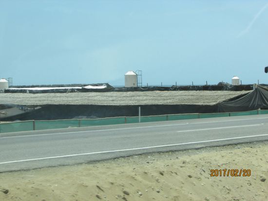 An der Straße riesige Hühnerställe, nur mit einer Plane abgedeckt ,