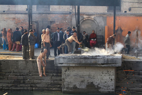 Kathmandu - Pashupatinath, Angehoerige spuelen die Asche ihres Verstorbenen in den Fluss  (2)