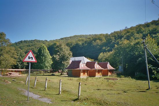 Drei Holzhäuschen auf dem Parkplatz laden zum Campen ein