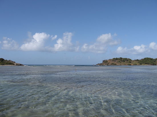 Hinter solchen Brandungsgürteln kann man im stillen Wasser ankern, Wasserfarbennavigation ist gefragt.