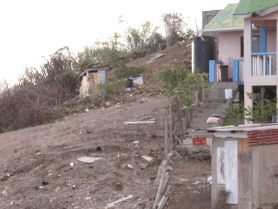 Ziegen haben die letzten Reste  der grünen Vegetation abgeknabbert und Hühner haben die Ackerkrume auf der Suche nach Futter aufgescharrt.  Hinter den Häusern Müll. Ein Blick in die Dritte Welt