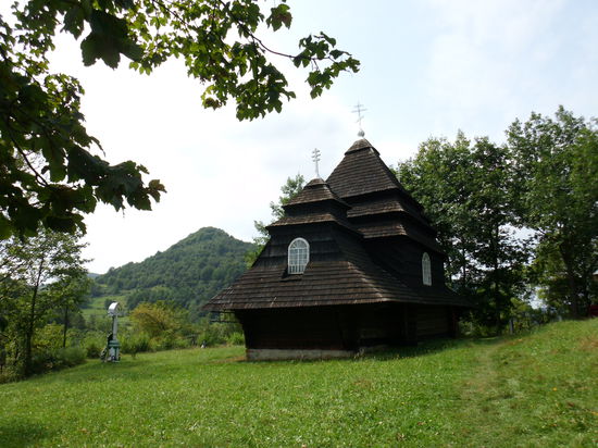 An der Abzweigung Richtung Volovez steht dieses kleine Holzkirchlein. Auf dem Hof sitzen ein paar Einheimische beim Bier. Sie winken mich heran.