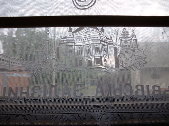 Ein Blick durch die Gardine aus dem Fenster. Im Gewebe kunstvoll eingestickt ein Bild des Hauptbahnhofs in Lemberg. Oder des Opernhauses von Odessa ?