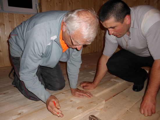 Erich begutachtet solide Handwerksarbeit: 4 cm dicke Fußbodenbretter, sauber auf Nut und Feder geschnitten und verlegt, da wird die junge Familie im Winter nie kalte Füße bekommen.
