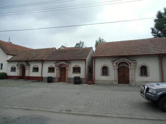 Die Eingänge zu den Weinkellern schön verziert mit kunstvoll geschnitzten Holztüren