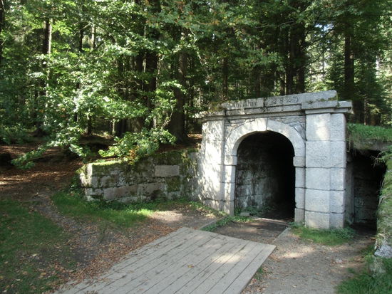 Dort steigt man zu diesem Portal auf und sieht in ein schwarzes Loch. In dem träge ein Bach dahinfließt.