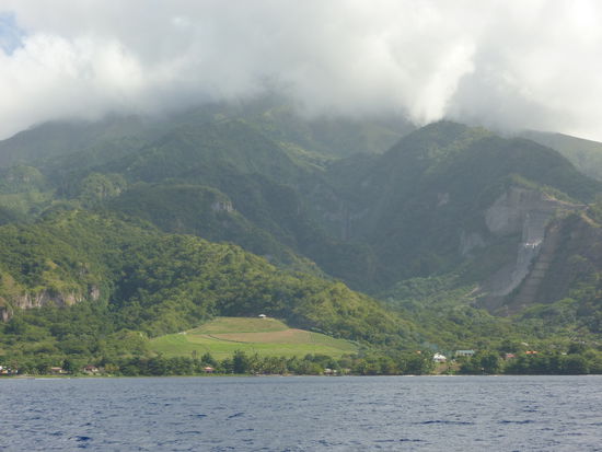 Dominica ist eine interessante naturbelassene Insel mit nur 72000 Einwohnern. Vulkanischen Ursprungs, wie man den Steilhängen aus Vulkanasche ansehen kann. Und hoch genug, ständig Regenwolken anzuzapfen. Es ist durchaus nicht sicher, dass wir den Schauer auch auf dem Wasser abkriegen.