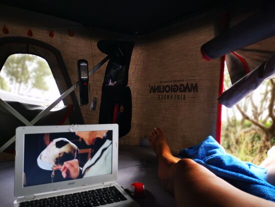 zum Glück regnet es unter den Bäumen nur so wenig, dass ich das Dachzelt offen lassen kann und so lässt sich er kleine Schauer mit einem Film überbrücken...