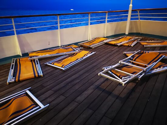 irgendwann wache ich auf, weil ein Mitarbeiter alle Liegen zusammen klappt und auf den Boden schmeißt - der Wind trieb die aufgeklappten Dinger alle auf einen Haufen bis an die Reling vor 