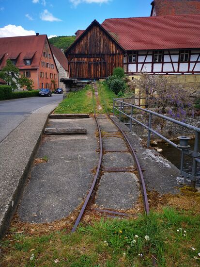 lustig: die Schiene kommt aus der Scheune und endet in der Wiese