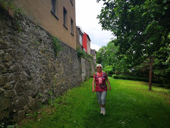 ein wunderschöner Weg in Saalburg an einer Mauer entlang, wo Wohnhäuser in die Mauer integriert eingebaut sind