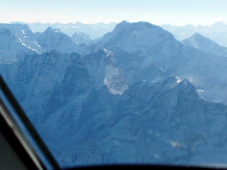 Erster Sichtkontakt mit Mount Everest aus dem Cockpit, noch weit weg, mitte links am Horizont