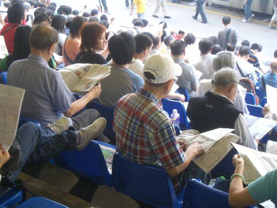 Jeder hat einen Zeitung mit den Renninformationen in der Hand ...