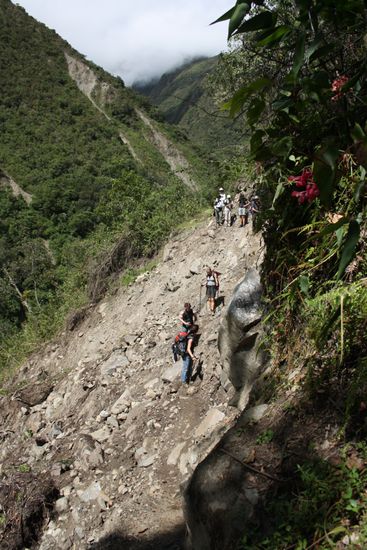Ein Erdrutsch verschuettet den Weg und verlangt Trittsicherheit.