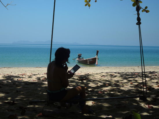 Mit E Reader auf der Schaukel