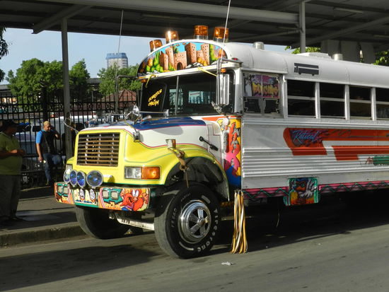 Phantasievoll lackierte Busse fahren durch Panamacity