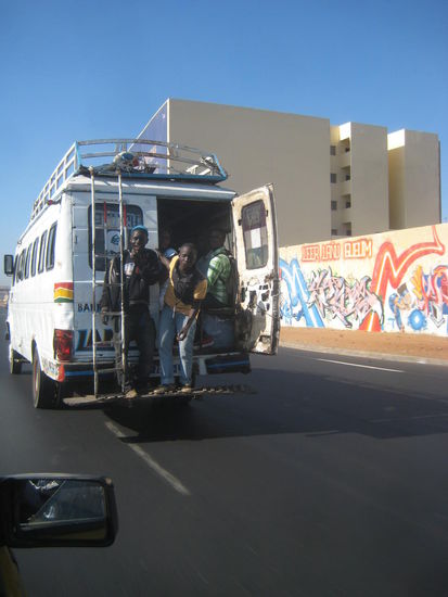 Abenteuerlich sind die Busse in Dakar unterwegs, die Zielausrufer und Kassierer stehen auch bei hohen Geschwindigkeiten hinten auf dem Trittbrett