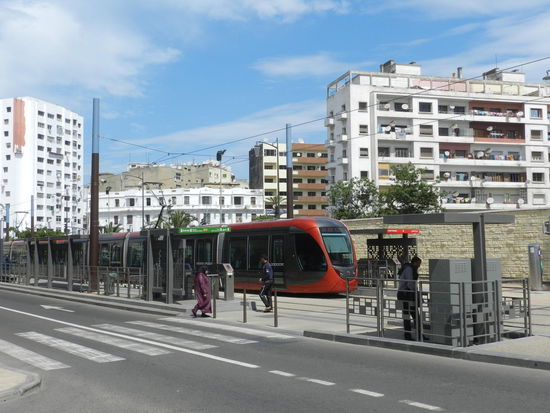 Straßenbahnzug vor gesichtslosen Wohn- und Geschäftshäusern