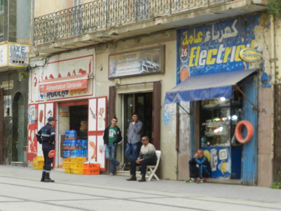 Sicherungsposten der Straßenbahngesellschaft neben abhängenden Bewohnern Orans