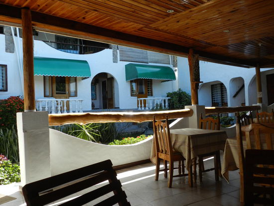 Blick von der Fruehstuecksterasse auf die Gaestezimmer im Guesthouse Calypha in Anse Etoile