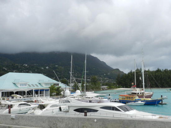 Tief hängen die Regenwolken über den Bergen; Blick vom Jachtanlegesteg auf die Berge