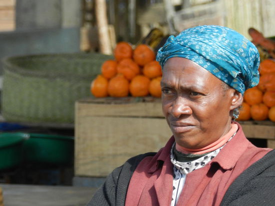 Kritisch dreinblickend wartet sie auf Käufer für ihr Obst.