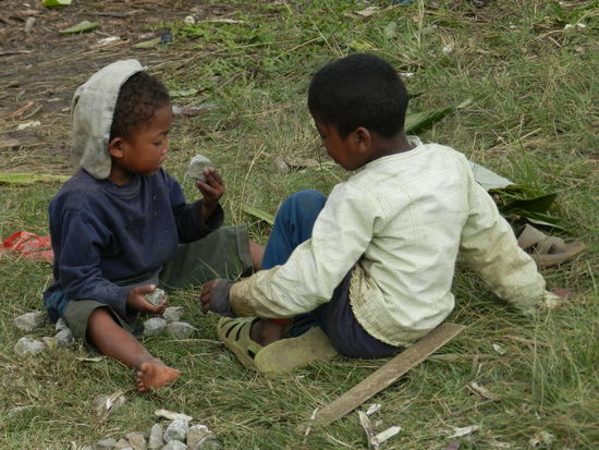 Kinder spielen mit den einfachsten Dingen, wenn man sie läßt - wie hier mit Schottersteinen.