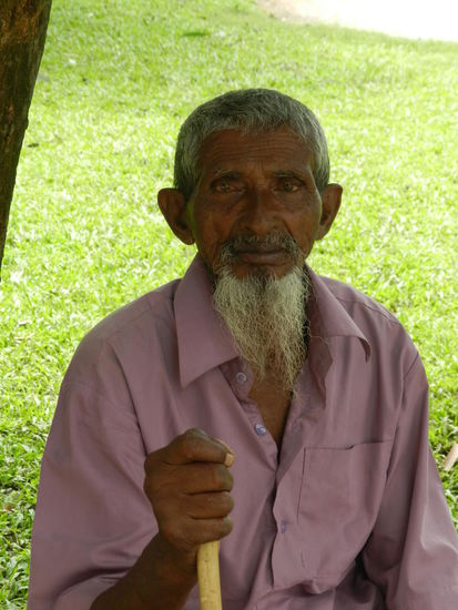 Dieser alte Herr sitzt auf der Dorfbank und schaut dem Leben im Ort zu