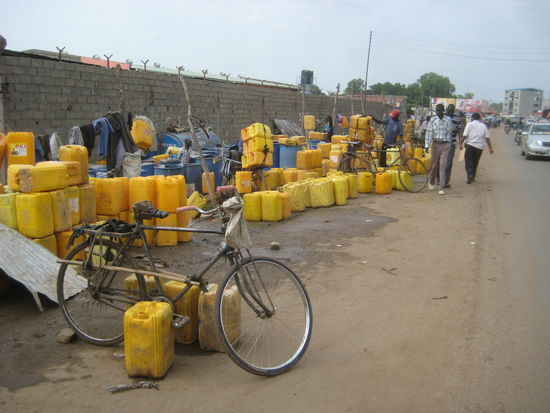 Trinkwasserverteilstelle; der Transport erfolgt per Fahrrad. Unglaublich, wieviele Kanister auf nur ein Rad passen.