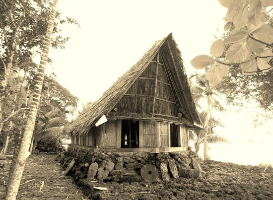 Frontansicht des men´s-houses, davor die Schätze der Dorfgemeinschaft