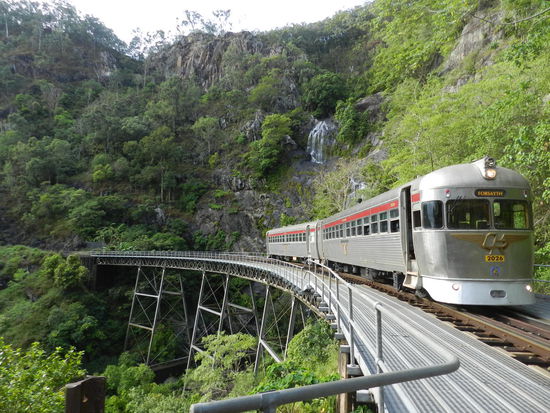 Der Savannahlander auf der höchsten Brücke dieser Strecke, im Hintergrund ein Wasserfall